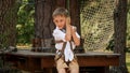 Handheld shot of smiling boy playing in adventure park and riding on the zip line. Active childhood, healthy lifestyle, kids Royalty Free Stock Photo
