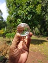 Handholding a crystal ball on blurred nature background