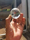 Handholding a crystal ball on blurred nature background Royalty Free Stock Photo