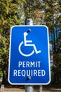 Handicap parking sign with trees in the background. Reserved parking lot for mobility or disable people Royalty Free Stock Photo