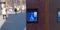 Handicapped access entrance pad mounted to a wall. Sign a button for a visa for people with disabilities Royalty Free Stock Photo