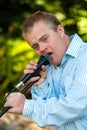 Handicapped boy singing on microphone. Royalty Free Stock Photo