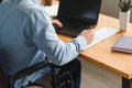 Handicapped Businessman Sitting On Wheelchair And Using Computer In Office Royalty Free Stock Photo