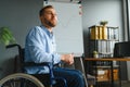 Handicapped Businessman Sitting On Wheelchair And Using Computer In Office Royalty Free Stock Photo