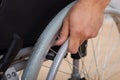 Handicapped man's hand pushing wheel of wheelchair