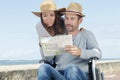 Handicapped man in wheelchair and girlfriend looking at map Royalty Free Stock Photo
