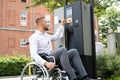Handicapped Man In Wheelchair Paying For Car Parking Ticket Royalty Free Stock Photo