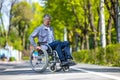 Handicapped man in wheelchair riding on street road, outdoor leisure for disable guy.