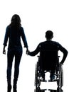 Handicapped man in wheelchair and woman holding hands silhouett