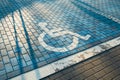Handicapped parking bay. Reserved parking sign for disabled spaces disabled blue parking sign painted on dark asphalt Royalty Free Stock Photo