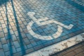 Handicapped parking bay. Reserved parking sign for disabled spaces disabled blue parking sign painted on dark asphalt Royalty Free Stock Photo