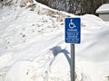 Handicapped parking sign in front of large pile snow parking lot Royalty Free Stock Photo