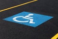 The blue, internationally recognized symbol indicating a handicapped parking space in a parking lot. Royalty Free Stock Photo