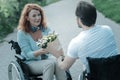 Handicapped woman taking bunch of flowers