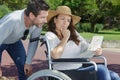 handicapped woman in wheelchair and boyfriend looking at map Royalty Free Stock Photo