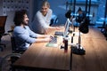 Handicapped young man with female colleague working in office. Disabled businessman in the wheelchair works in the office at the