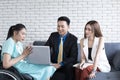 Handicapped young woman talking with colleagues using laptop computer in office. Disabled business executive on wheelchair using l Royalty Free Stock Photo