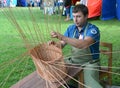 The handicraftsman spins a basket from a rod at fair of national creativity Royalty Free Stock Photo