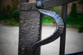 Handle on the gate in the black, cast-iron old gate blocking the entrance to the house.