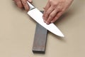 Handle the knife to make a sharp knife with a whetstone. Royalty Free Stock Photo
