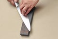 Handle the knife to make a sharp knife with a whetstone. Royalty Free Stock Photo