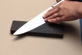 Handle the knife to make a sharp knife with a whetstone. Royalty Free Stock Photo
