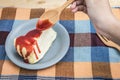 Handle wooden spoon pour strawberry jam topping on crepe cake Royalty Free Stock Photo