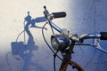 Handlebars of old rusty bike throwing shadows on white wall Royalty Free Stock Photo