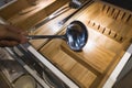 Handling a big stainless steel ladle out of the storage contain Royalty Free Stock Photo