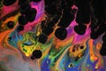 Abstract acrylic pour painting in vibrant neon colors that resembles flames.