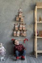 Handmade advent calendar in craft bag hanging on the wall, boy sitting on the floor looking at Christmas presents Royalty Free Stock Photo