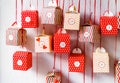 Handmade advent calendar gift boxes hanging on the wall.