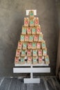 Handmade advent calendar presents in craft bags hanging on a wooden Christmas tree. Creative present with numbers for