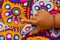 handmade ahir embroidery Gujarat indian,Detail old colorful patchwork carpet, India. baby hand on embroidery close up view