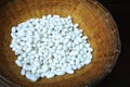 Natural white silkworm cocoons in a vintage bamboo basket