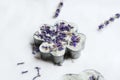 Handmade  bar with lavender flowers in metal form on white paper, closeup Royalty Free Stock Photo
