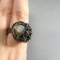 Handmade uniq big brutal ring on the hand on grey background