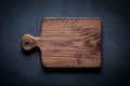 Handmade black walnut wood cutting board on the dark tabletop.