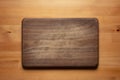 Handmade black walnut wooden chopping board with traces of knife carving on the table.