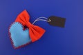Blue felt heart with red bow tie and blank label tag Royalty Free Stock Photo
