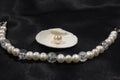 Handmade bracelet with river white pearls and a pearl in the shell on a black background. Royalty Free Stock Photo