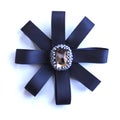 Handmade brooch from dark blue tapes and a rhinestone