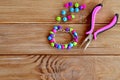 Handmade button bracelet. Set of bright colored buttons, pliers. DIY bangle jewelry idea. Easy make creative crafts Royalty Free Stock Photo