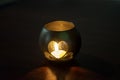 A handmade candle holder. A candle holder made of a glass jar, in the shape of a heart, stands on a table in a dark Royalty Free Stock Photo