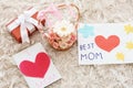 Handmade cards, basket with flowers and gift box on carpet. Mother's day celebration Royalty Free Stock Photo