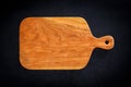 Handmade cherry wood wooden chopping board on black wooden board. North American cherry wood pallet.