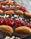 Handmade chocolate bar filled with almonds, cherries and sesame seeds.