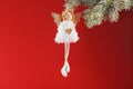 Handmade christmas angel toy on a Christmas tree on a red background Royalty Free Stock Photo