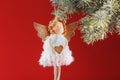 Handmade christmas angel toy on a Christmas tree on a red background Royalty Free Stock Photo
