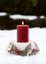 Handmade Christmas candle holder in shape of cake made of ice, red rose hips berries, holly berry branches and thuja twigs Royalty Free Stock Photo